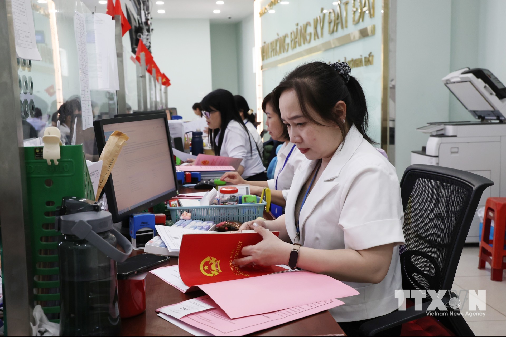 Cán bộ Văn phòng Đăng ký đất đai Thành phố Hồ Chí Minh số 2 (khu vực Cát Lái) giải quyết thủ tục đất đai cho người dân. (Ảnh: Hồng Đạt/TTXVN)